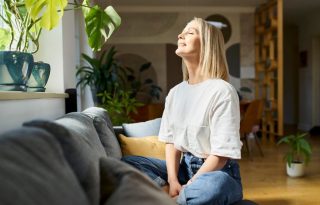 Pripremite se za psihičko prolećno čišćenje; plavokosa žena sedi na krevetu i medititra