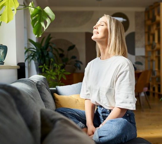 Pripremite se za psihičko prolećno čišćenje; plavokosa žena sedi na krevetu i medititra